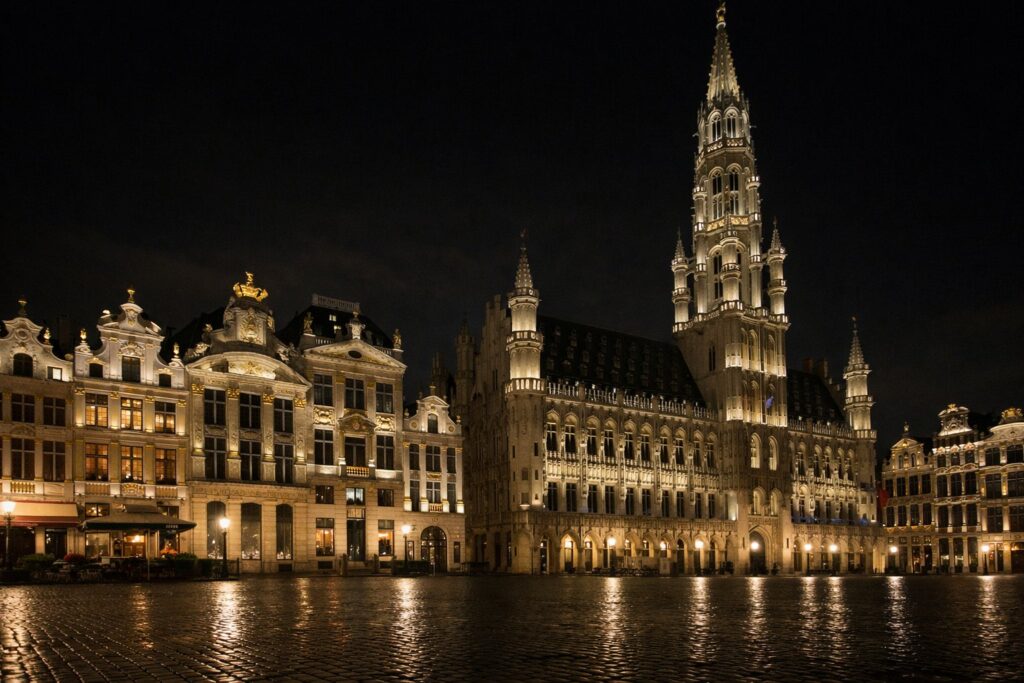 Grande praça com casas das guildas e câmara gótica à noite