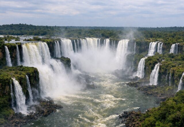 Cortina de cataratas numa garganta de floresta tropical com neblina