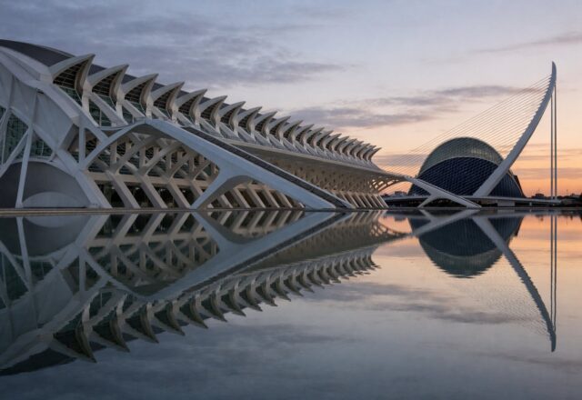 Arcos brancos de arquitetura contemporânea refletidos num espelho de água ao amanhecer